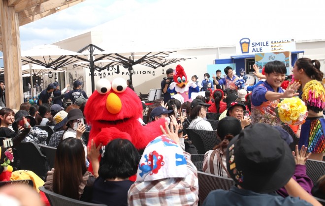 Elmo, Snoopy, and Woody Woodpecker perform at the “Thanks Love Month Special Stage in Osaka Healthcare Pavilion,” delighting visitors with dance and heartfelt gratitude at Expo 2025.